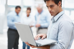 Man holding laptop in corporate setting